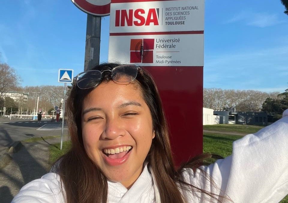 Dona smiling in front of the INSA Toulouse sign