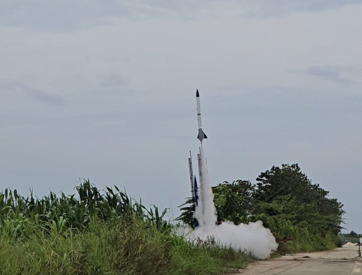 The Archernauts model rocket lifting off from a field